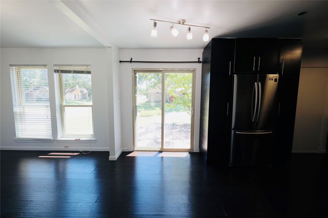 Kitchen featuring dark cabinetry, freestanding refrigerator, wood finished floors, and modern cabinets | Image 13