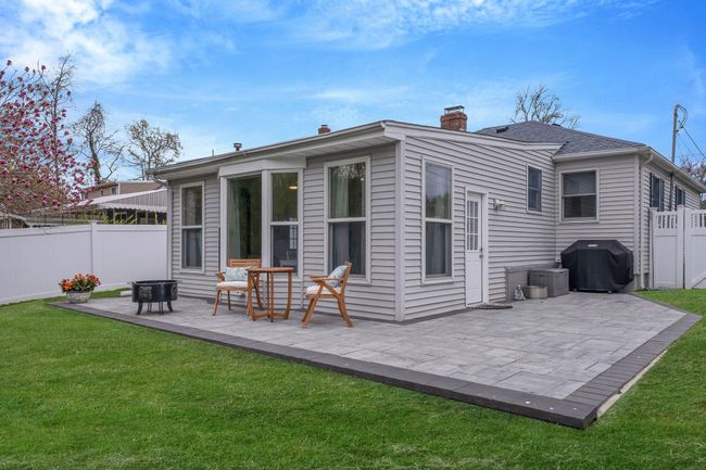 Rear view of property featuring a chimney, fence, a patio, and a lawn | Image 10