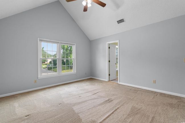 Carpeted empty room with ceiling fan and high vaulted ceiling | Image 23
