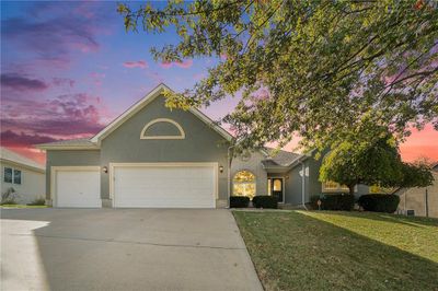 View of front of house featuring a garage and a lawn | Image 1