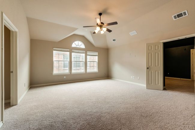 Unfurnished bedroom featuring carpet floors, lofted ceiling, baseboards, and ceiling fan | Image 16