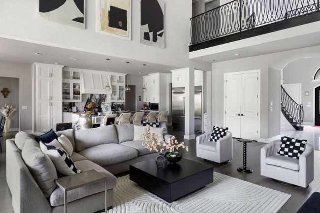 Living room featuring arched walkways, a high ceiling, dark wood-style flooring, and baseboards | Image 5