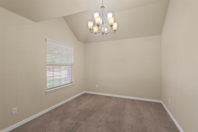 Carpeted empty room with a chandelier and vaulted ceiling | Image 15