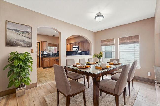 Dining area featuring light wood-style flooring and arched walkways | Image 6