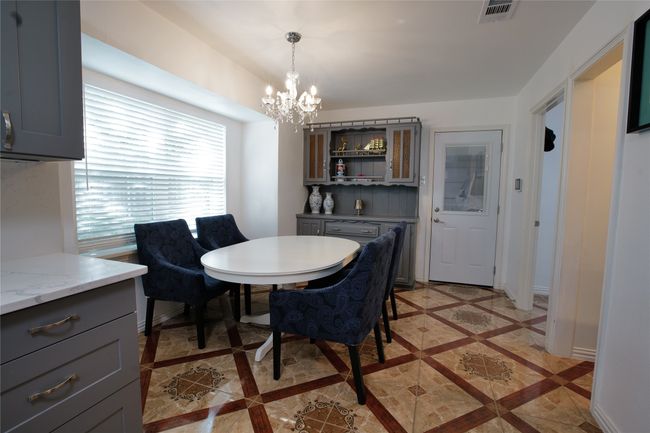 Dining area with a chandelier and inlaid floor details | Image 15