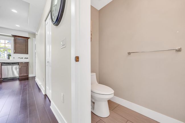Bathroom with toilet, vanity, recessed lighting, wood finished floors, and baseboards. Powder Room | Image 12