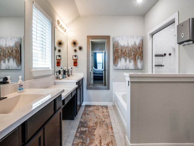 Ensuite bathroom featuring double vanity, walk in shower, a wealth of natural light, and a garden tub | Image 22