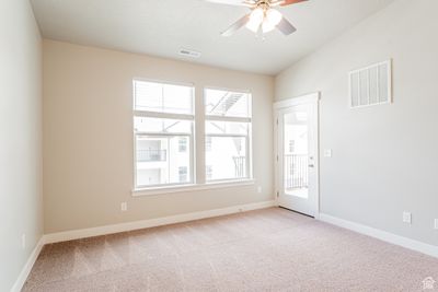 Carpeted spare room with plenty of natural light and ceiling fan | Image 3