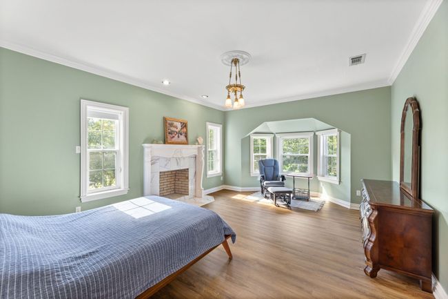 Bedroom with ornamental molding, luxury vinal planing floors, a fireplace, and recessed lighting | Image 30