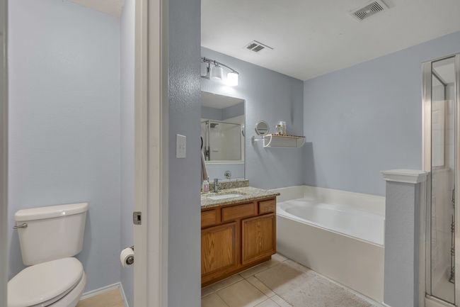 Full bath featuring a bath, vanity, a stall shower, and tile patterned floors | Image 21