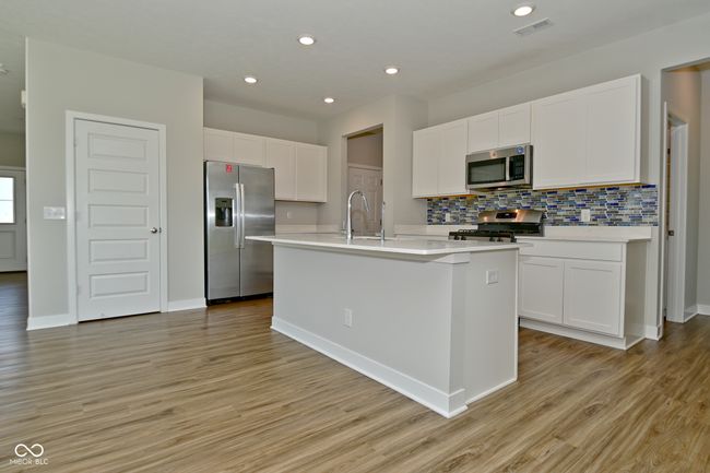 kitchen featuring tasteful backsplash, visible vents, white cabinetry, stainless steel appliances, and light wood-style flooring | Image 12
