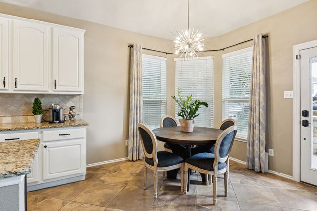 Dining space with a chandelier open to the kitchen and windows to the backyard | Image 13