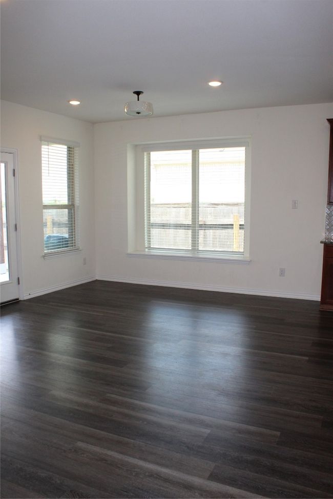 Unfurnished living room with dark wood-type flooring, baseboards, and recessed lighting | Image 15