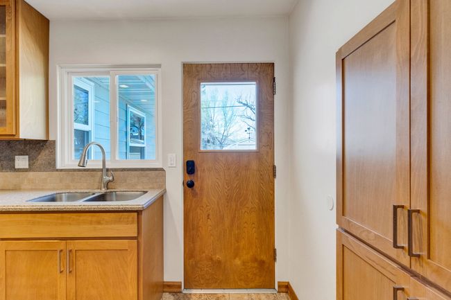 Kitchen featuring tasteful backsplash, glass insert cabinets, dishwasher, and a sink | Image 8