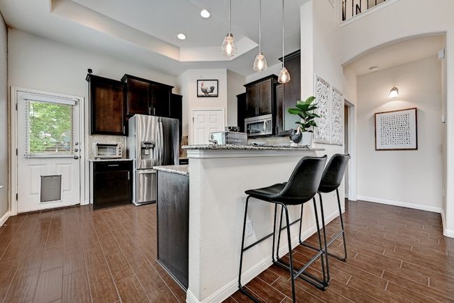 The kitchen features a breakfast bar with handsome pendant lighting | Image 5