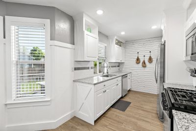 Kitchen featuring light hardwood / wood-style flooring, a wealth of natural light, and white cabinetry | Image 2