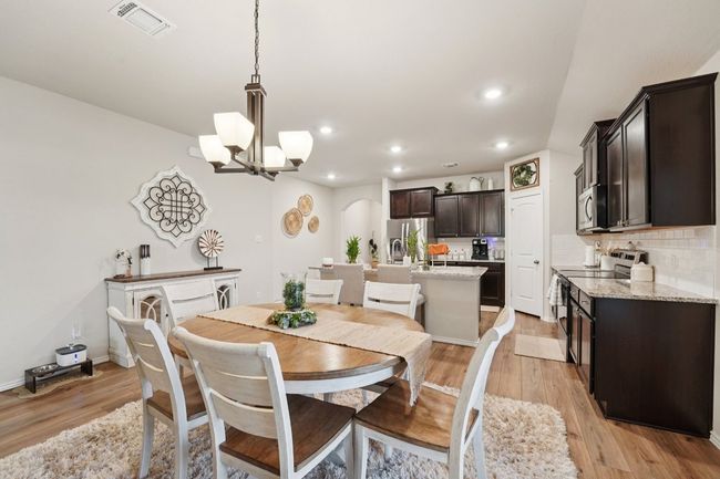 Dining space featuring arched walkways, a chandelier, light wood-style flooring, and recessed lighting | Image 10