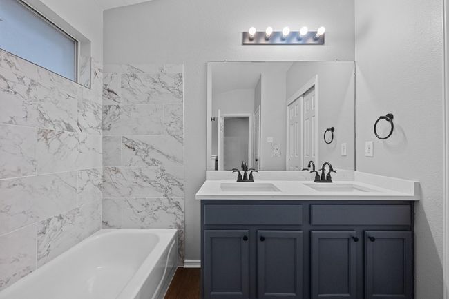Full bathroom with new double vanity, finished floors, and shower / bathtub combination | Image 15