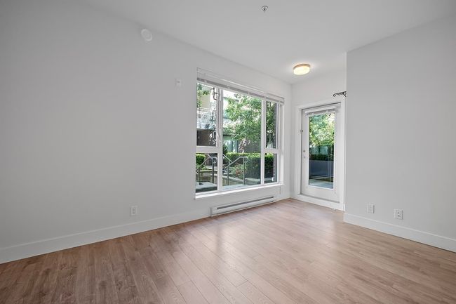 Empty room featuring a baseboard radiator and wood finished floors | Image 17