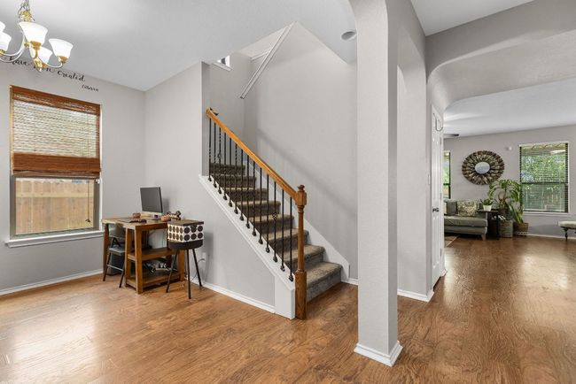 Staircase with a chandelier, wood finished floors, and baseboards | Image 14