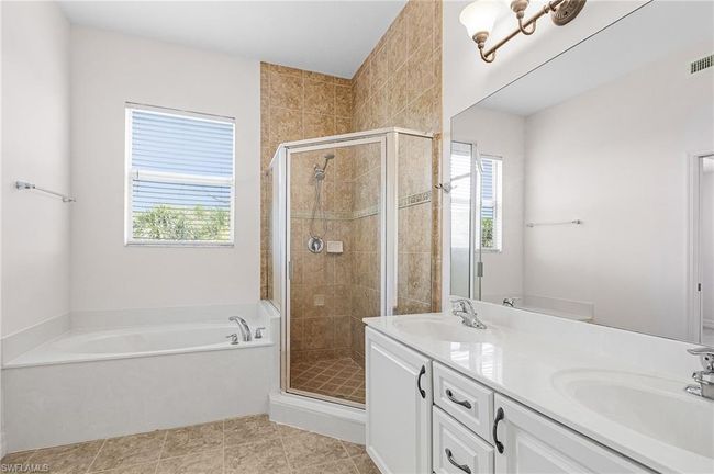 Bathroom featuring a bath, healthy amount of natural light, a shower stall, and double vanity | Image 24