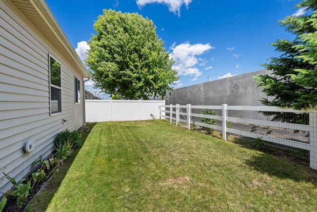Rear yard on the east side with tulip plantings along the foundation. | Image 17