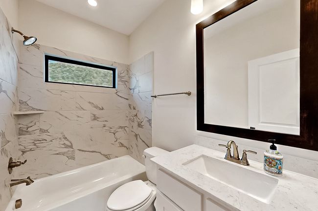 Full bathroom featuring toilet, washtub / shower combination, and vanity | Image 26