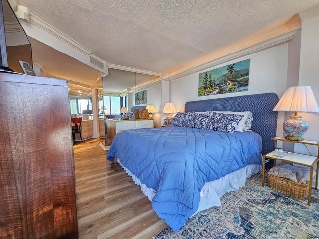 Bedroom featuring crown molding, a textured ceiling, and wood finished floors | Image 23