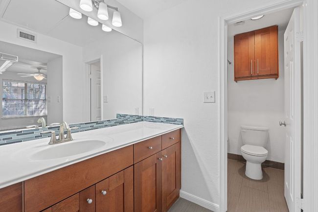 Bathroom featuring visible vents, baseboards, toilet, vanity, and a ceiling fan | Image 28