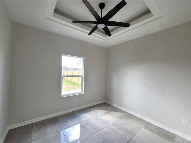 Unfurnished room featuring a tray ceiling and ceiling fan | Image 15