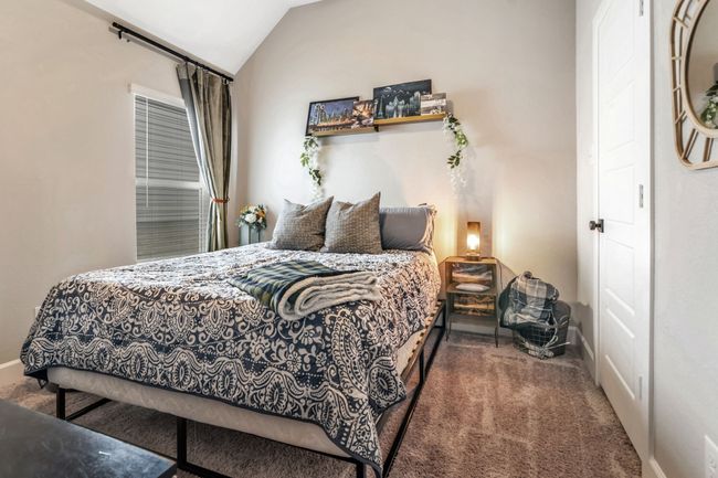 Carpeted bedroom with vaulted ceiling and baseboards | Image 22