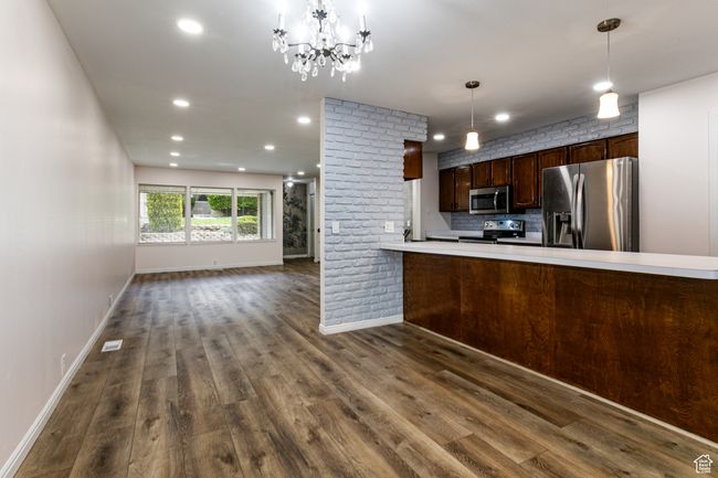 Kitchen featuring appliances with stainless steel finishes, dark wood-type flooring, baseboards, recessed lighting, and light countertops | Image 10