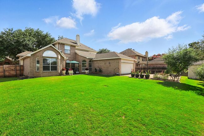 Back of house featuring a fenced backyard, brick siding, and a chimney | Image 30