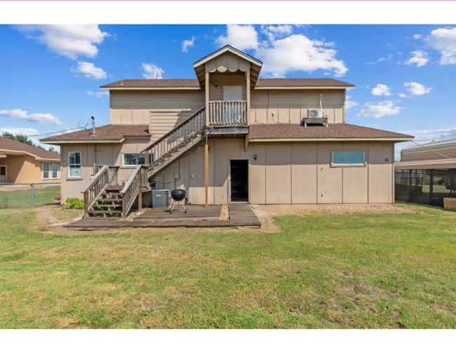 Back of property with stairs, roof with shingles, a lawn, and a wooden deck | Image 31