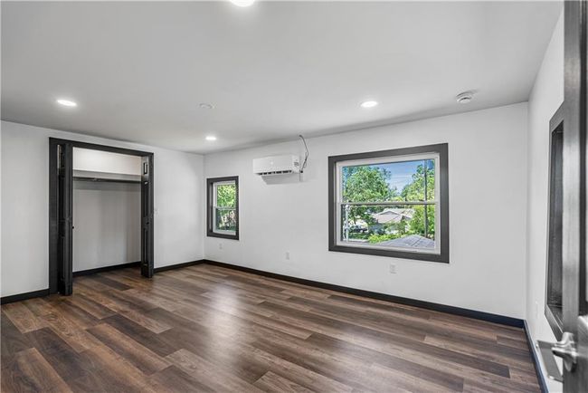 Upstairs bedroom with dark wood-style flooring, recessed lighting, baseboards, and a closet | Image 38