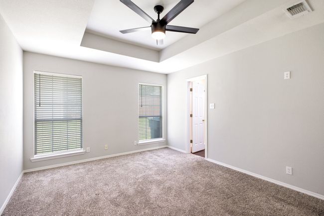 Empty room featuring ceiling fan, carpet flooring, and a tray ceiling | Image 29