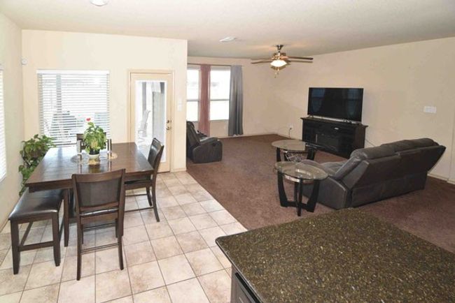 Living area featuring light colored carpet, a ceiling fan, and light tile patterned floors | Image 9
