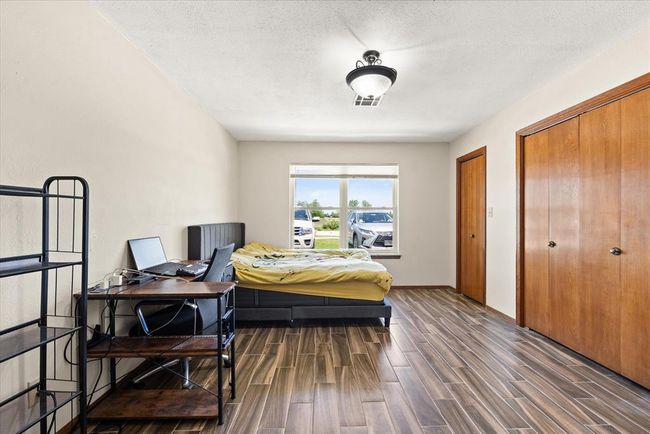 Bedroom featuring dark wood finished floors, an office area, and baseboards | Image 32