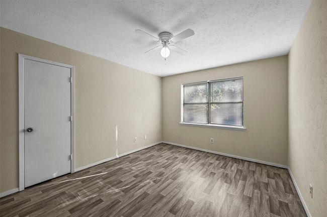 Unfurnished room with wood finished floors, a ceiling fan, and a textured ceiling | Image 10