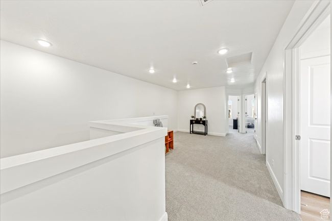 Hallway with attic access, light colored carpet, and recessed lighting | Image 17