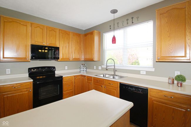 This spacious kitchen offers everything you need for easy living. Enjoy the functionality of a center island, the storage of a pantry, and the convenience of all appliances being included - unpack and start cooking! | Image 7