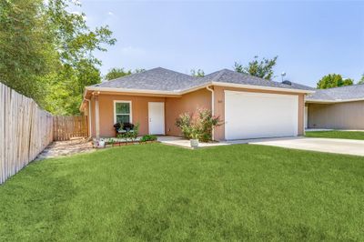 Ranch-style home featuring a front lawn and a garage | Image 2