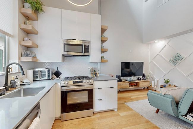 Kitchen featuring open shelves, appliances with stainless steel finishes, a sink, light wood-style floors, and open floor plan | Image 4