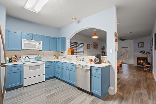 The heart of the home is a beautiful kitchen with wrap around counters, custom cabinet color, electric stove, microwave, and recent refrigerator with is included. | Image 11