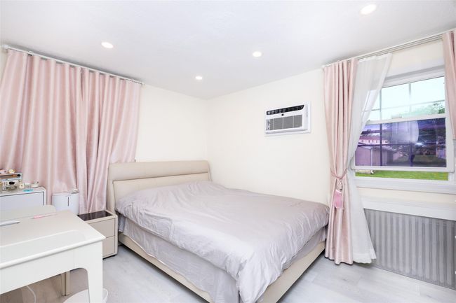 Bedroom with radiator, recessed lighting, a wall mounted air conditioner, and light wood-type flooring | Image 15