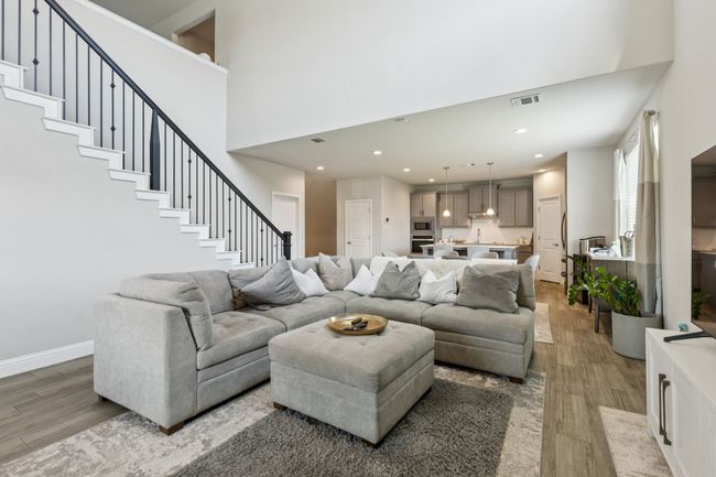 Living area featuring wood-style tile floors, stairway, a high ceiling, and recessed lighting | Image 4