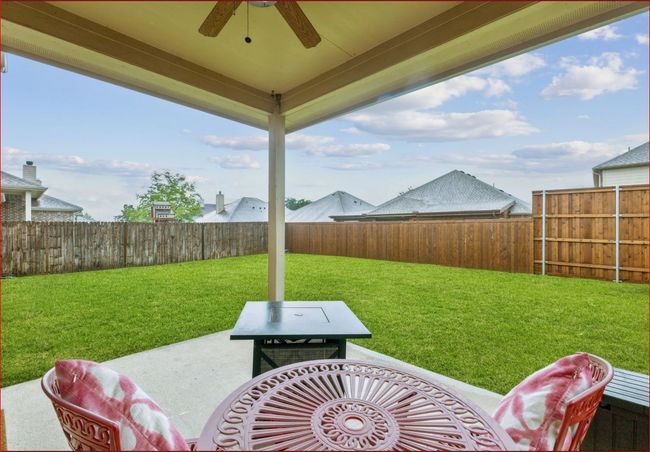 Fenced backyard with a ceiling fan and a patio area | Image 27