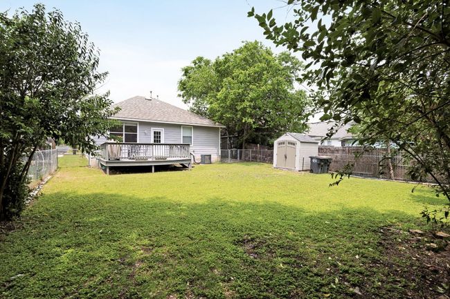 View of yard with a fenced backyard, an outbuilding, central air condition unit, a wooden deck, and a shed | Image 35