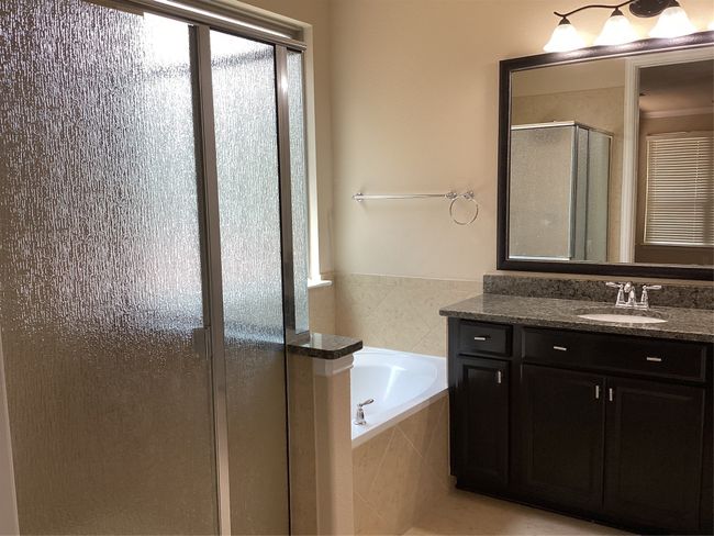 Bathroom featuring a stall shower, a garden tub, and vanity | Image 13