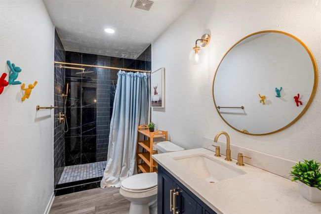 The second full bathroom offers modern finishes, a walk-in shower, and a spacious vanity with ample storage. | Image 22